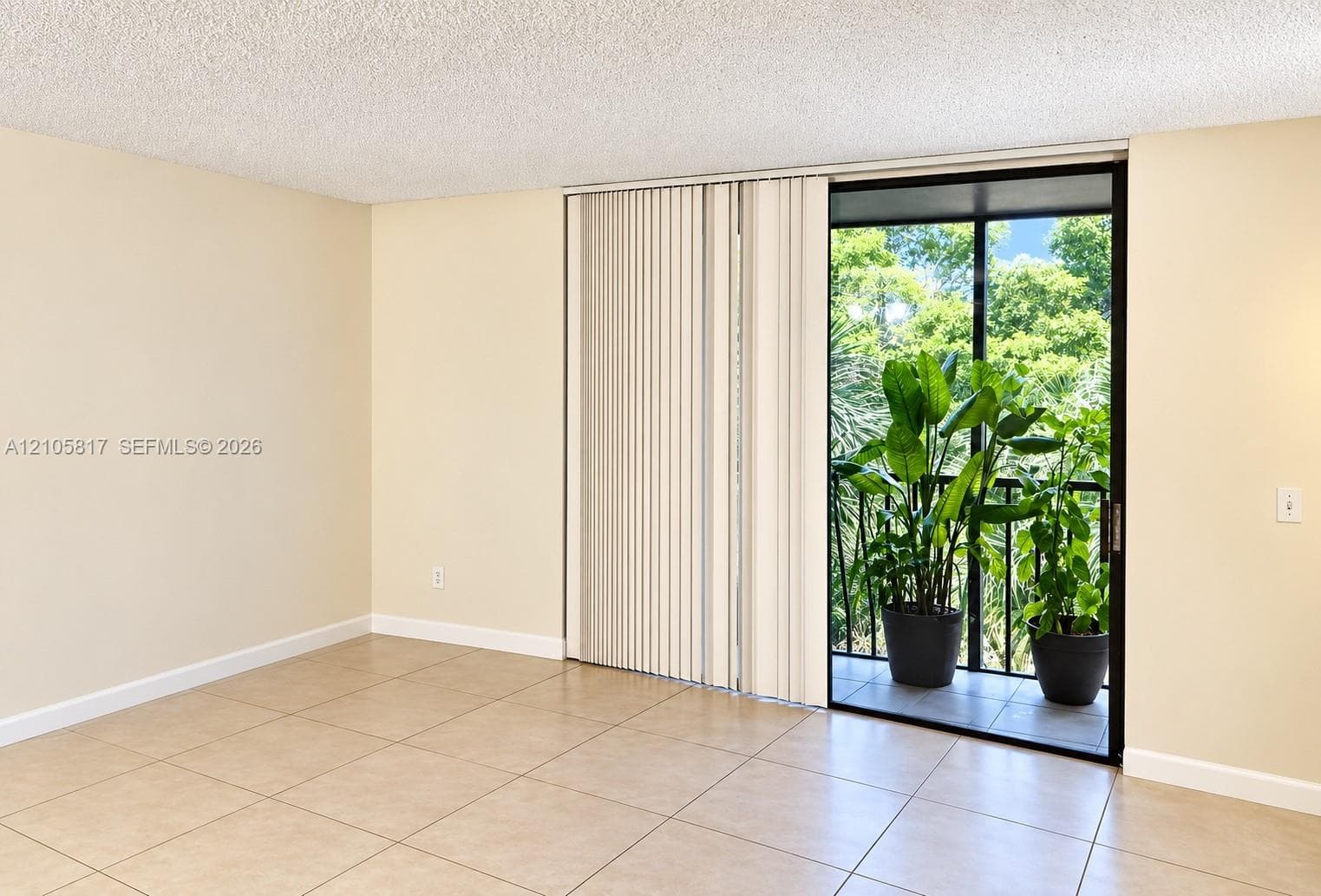 Neutral-tone ceramic tile flooring and sliding glass door with integrated vertical blinds opening to a private balcony