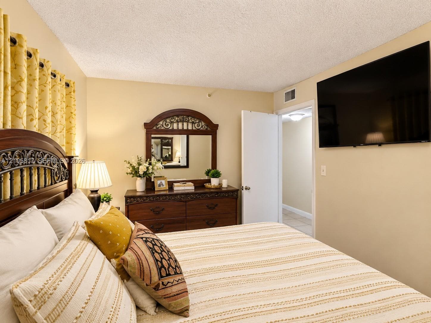 Neutral wall palette featuring a textured ceiling finish and a standard white interior door