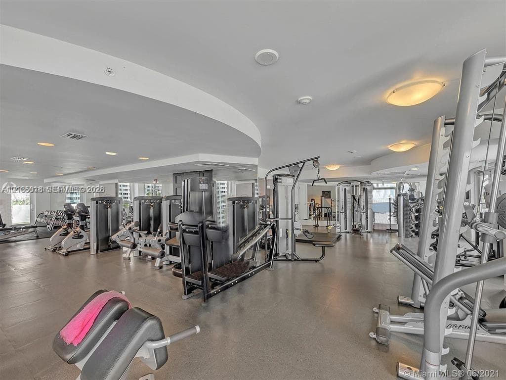 Fitness center featuring recessed lighting, mirrored walls, and specialized rubberized flooring