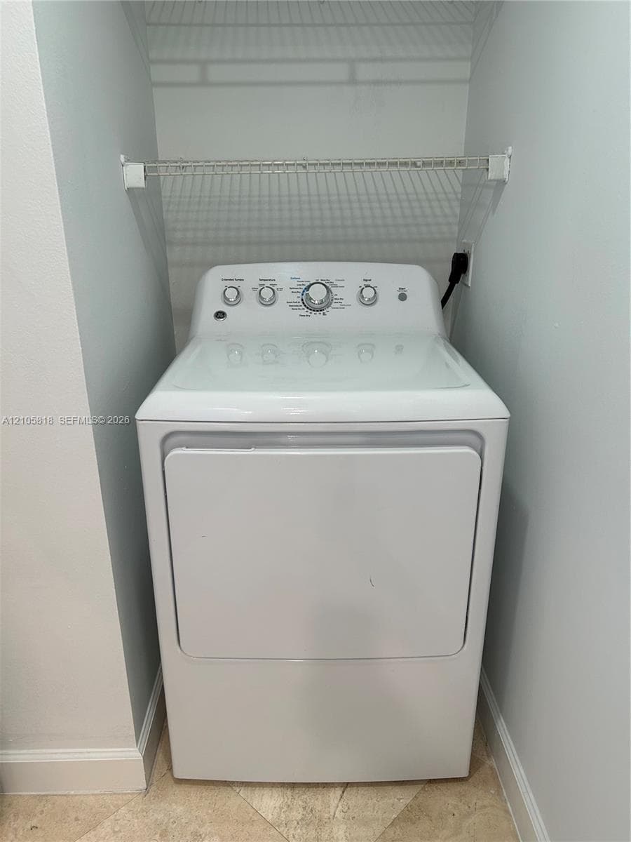 Laundry alcove featuring a top-load washing machine and an overhead wire storage shelf