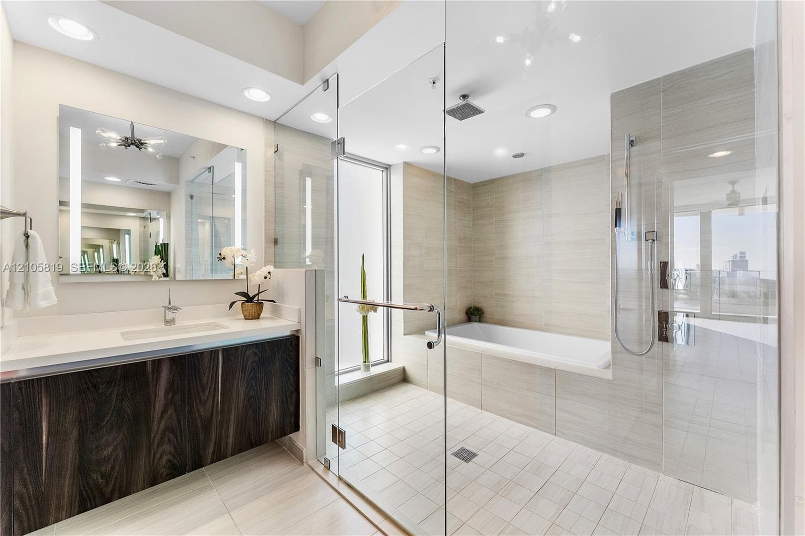 Primary Bathroom with Dual Backlit Sinks, Glass enclosed Shower & Tub as well as Hidden Water Closet.