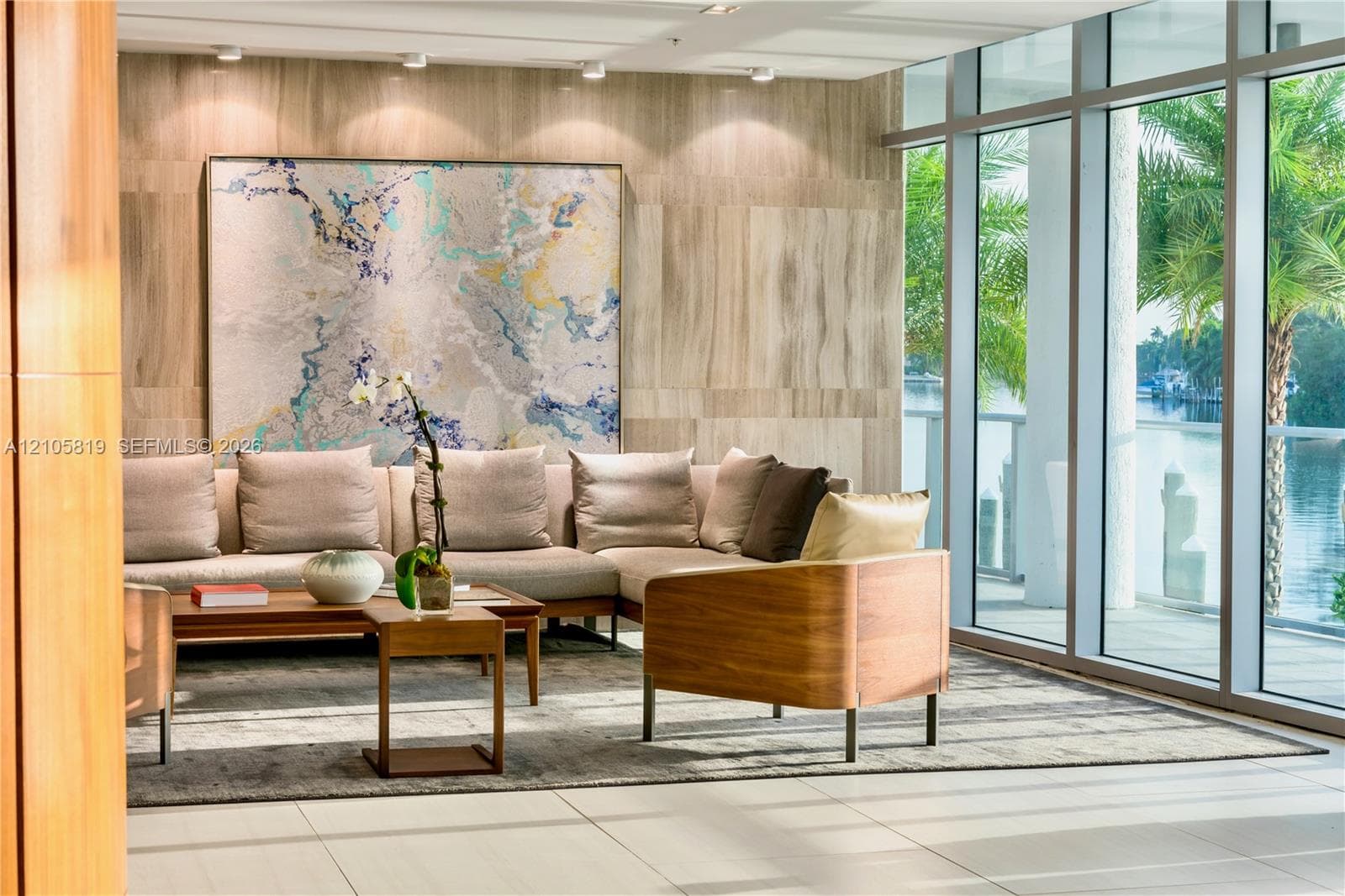 Waterfront Lobby.  Floor-to-ceiling glass windows, stone panel wall cladding, recessed ceiling lighting, and large-format tile flooring