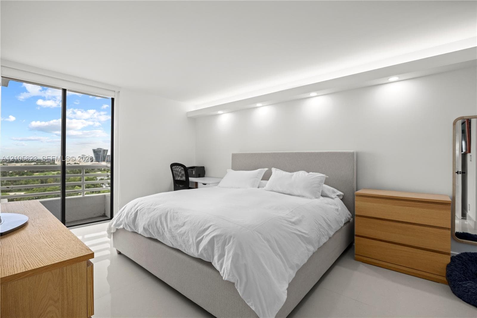 Floor-to-ceiling sliding glass doors, built-in cove lighting, recessed ceiling lights, and polished tile flooring