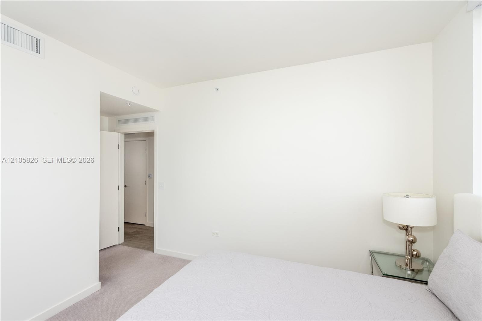 Neutral-toned interior featuring wall-to-wall carpeting, crisp white walls, and solid-core interior doors