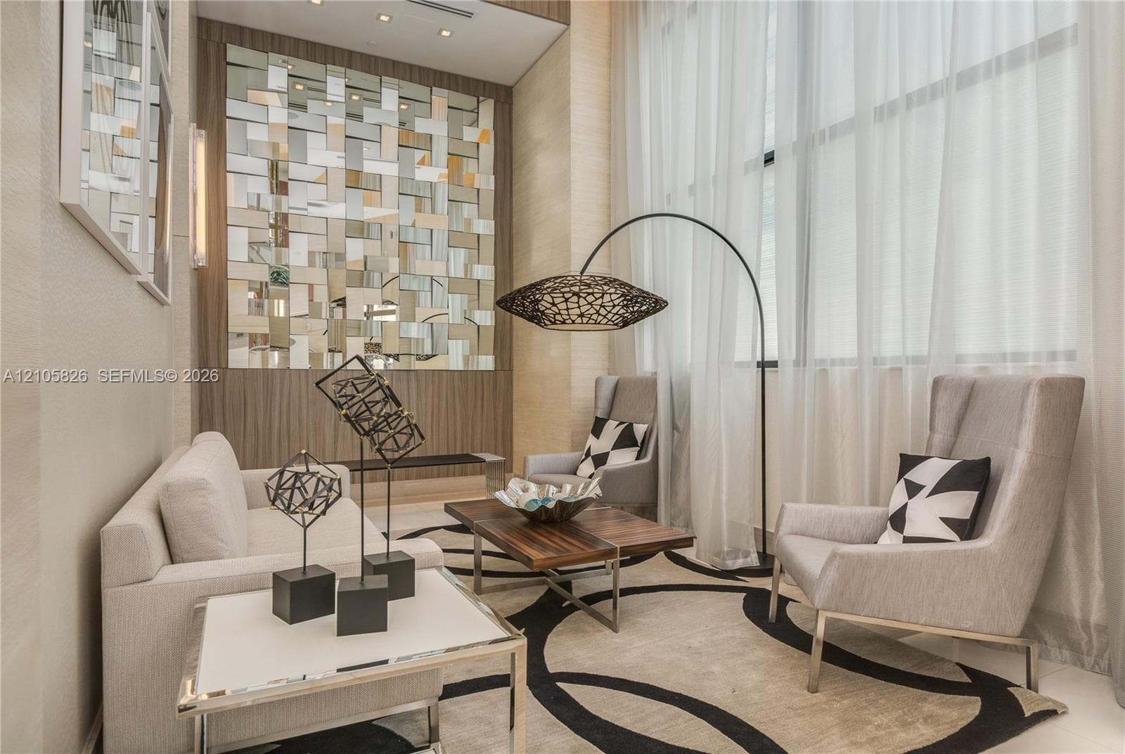 Double-height ceilings, decorative mirrored wall feature, floor-to-ceiling windows, and recessed ceiling lighting