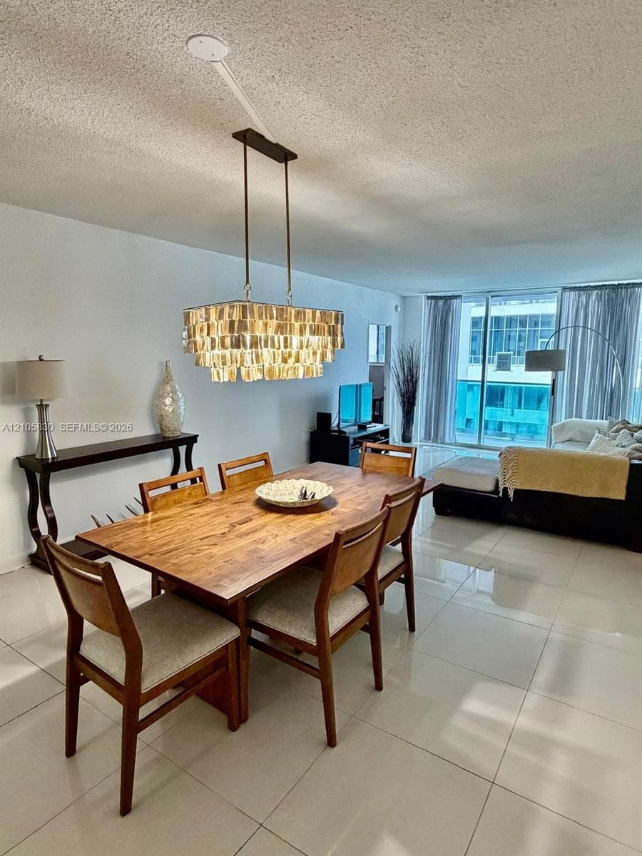 Large-format tile flooring, multi-tiered rectangular pendant lighting, and floor-to-ceiling sliding glass doors