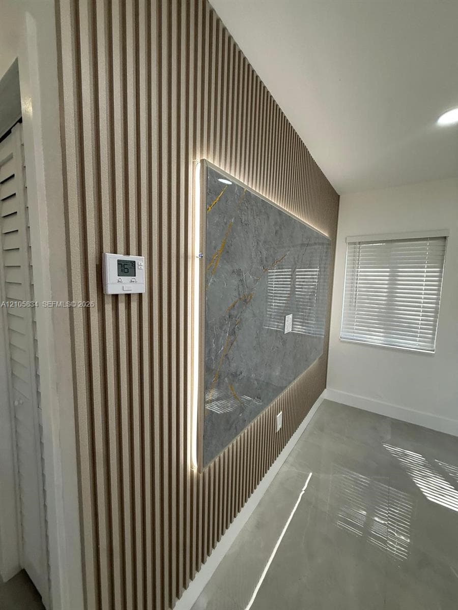 Vertical wood-slat wall paneling featuring an integrated stone-finish accent panel, recessed backlighting, and polished concrete-style flooring