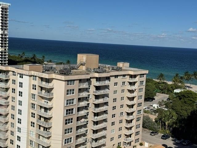 High-rise building featuring private balconies, stucco exterior, and oceanfront positioning