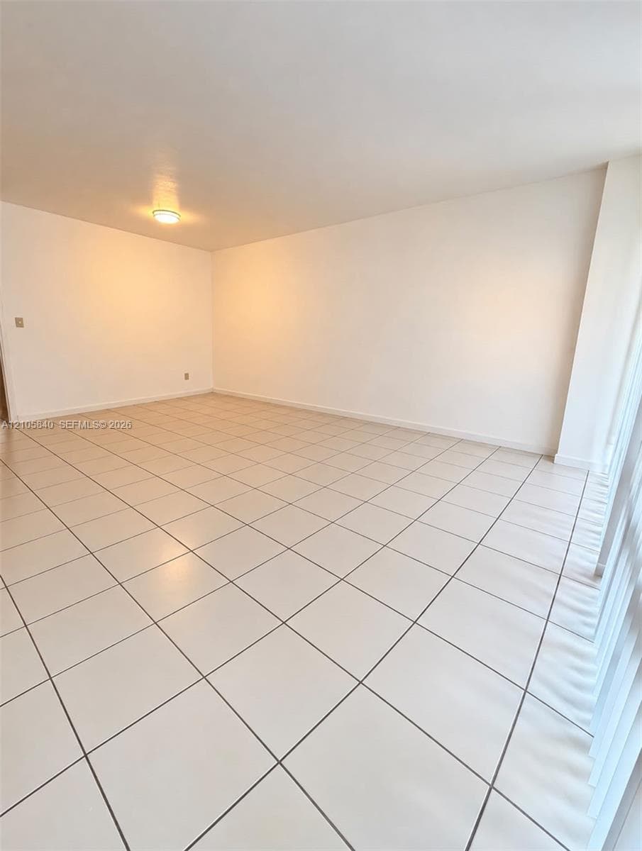 Neutral-toned ceramic tile flooring, smooth wall surfaces, and flush-mount overhead lighting
