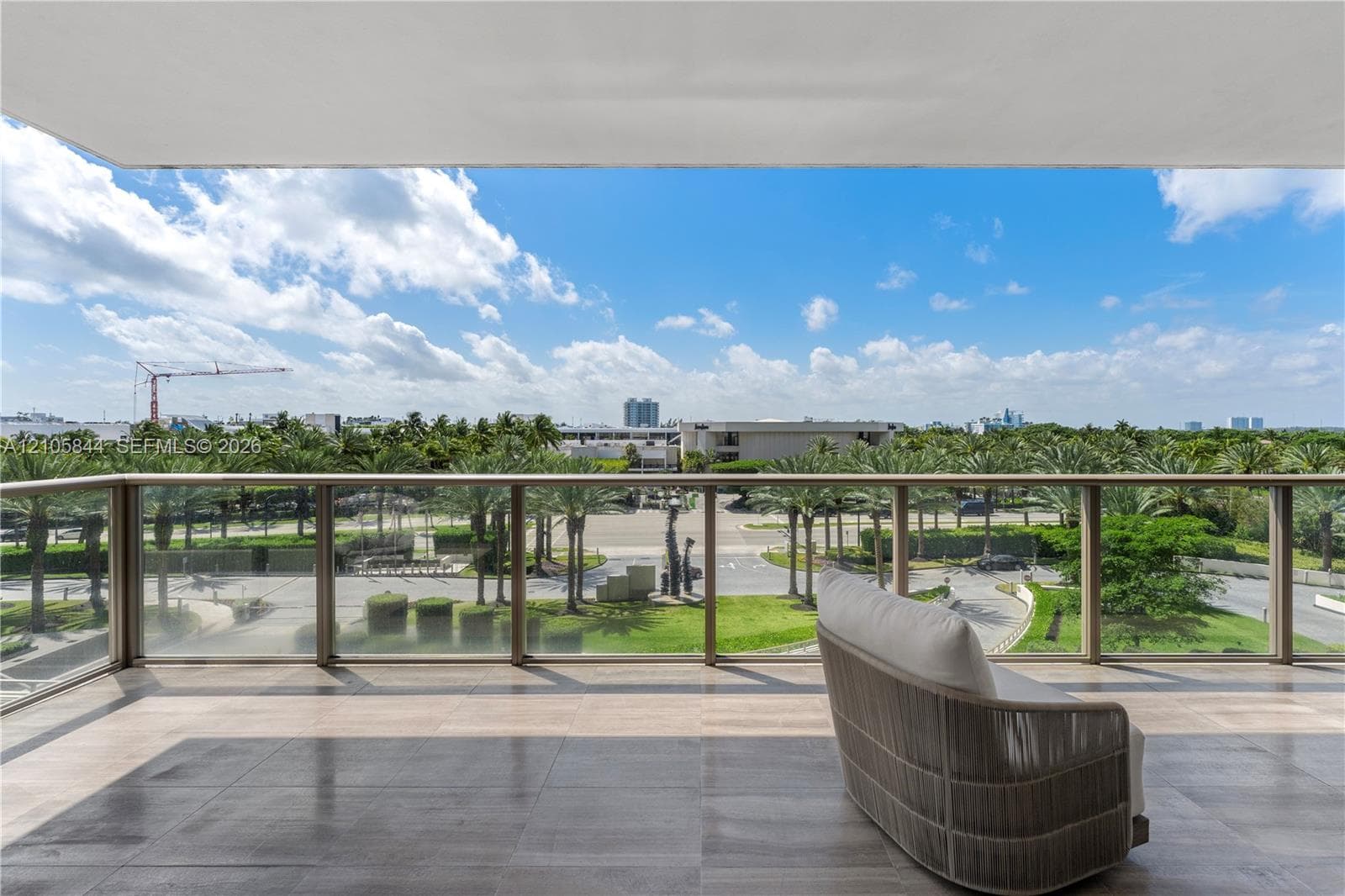 Covered balcony featuring tile flooring and a glass-panel railing