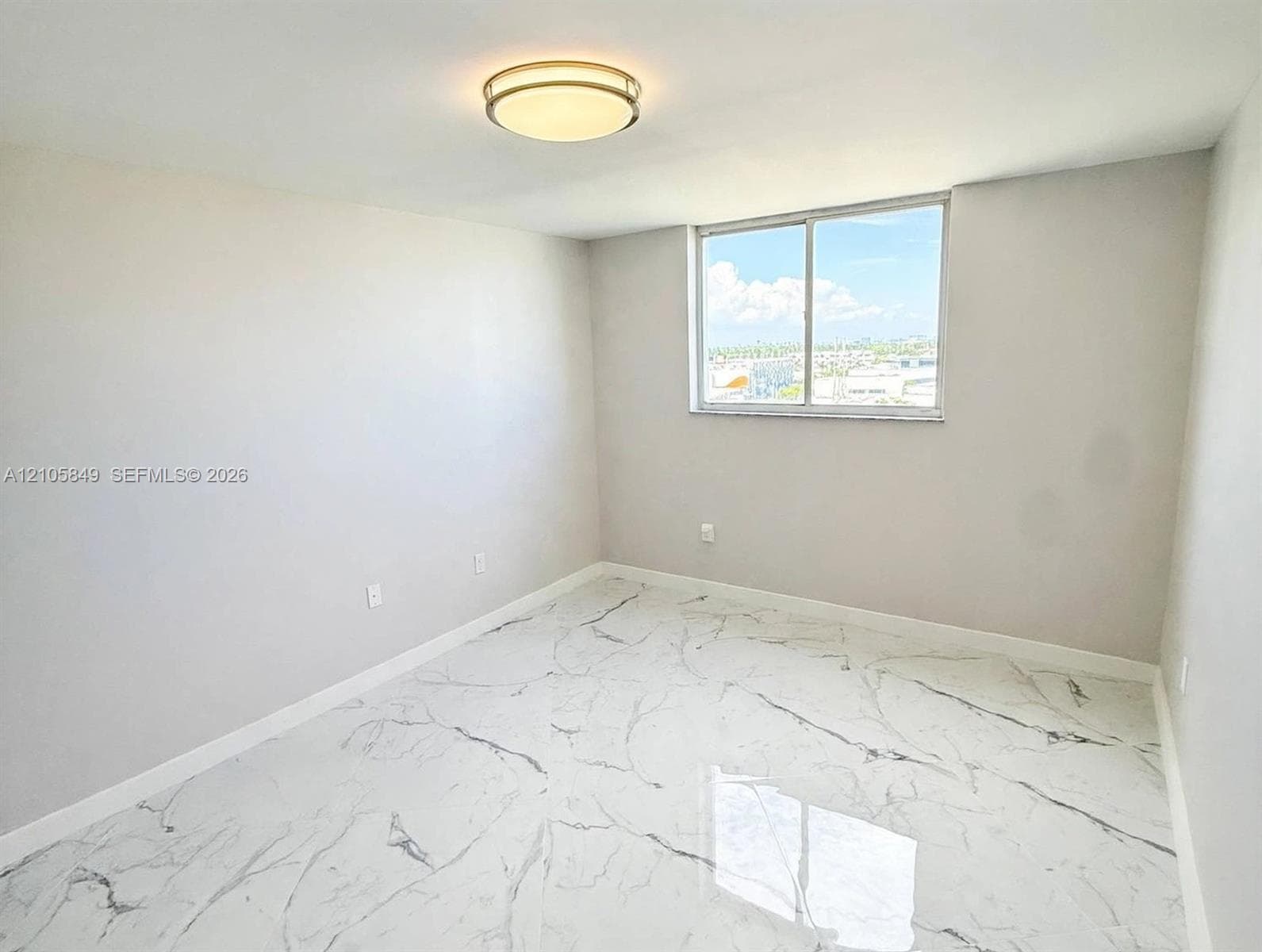 Walk-in storage space featuring white walls and tile flooring with a veined pattern, equipped with dual white wire shelving systems