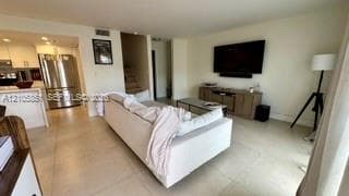 Open-concept living space featuring large-format tile flooring, neutral wall tones, and recessed lighting