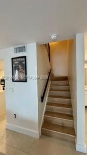 Staircase featuring wood-finish treads and a dark-finished handrail