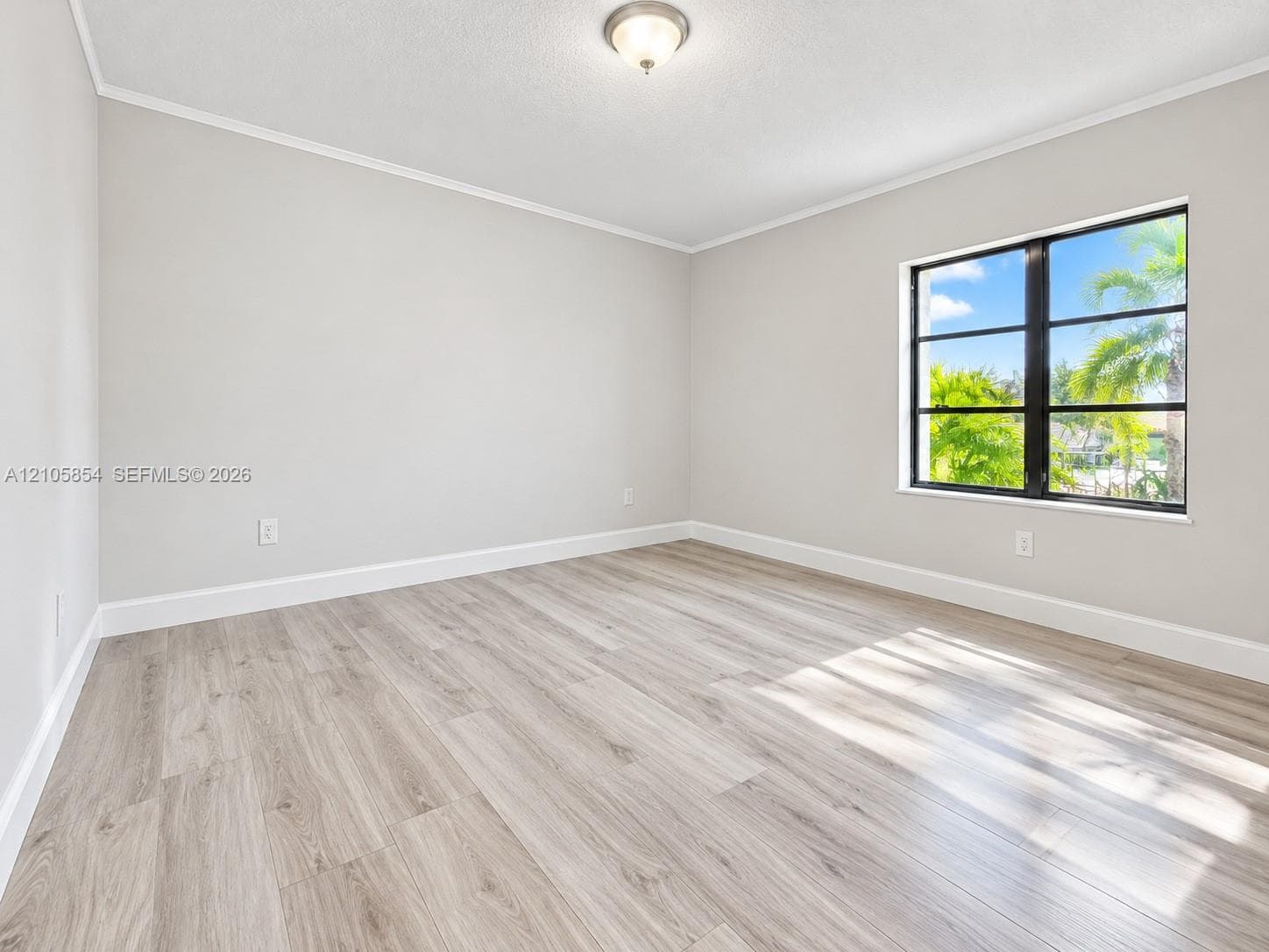 Edited image of third bedroom showing how the room would look without furniture, highlighting its spacious layout, beautiful flooring and nice tree view
