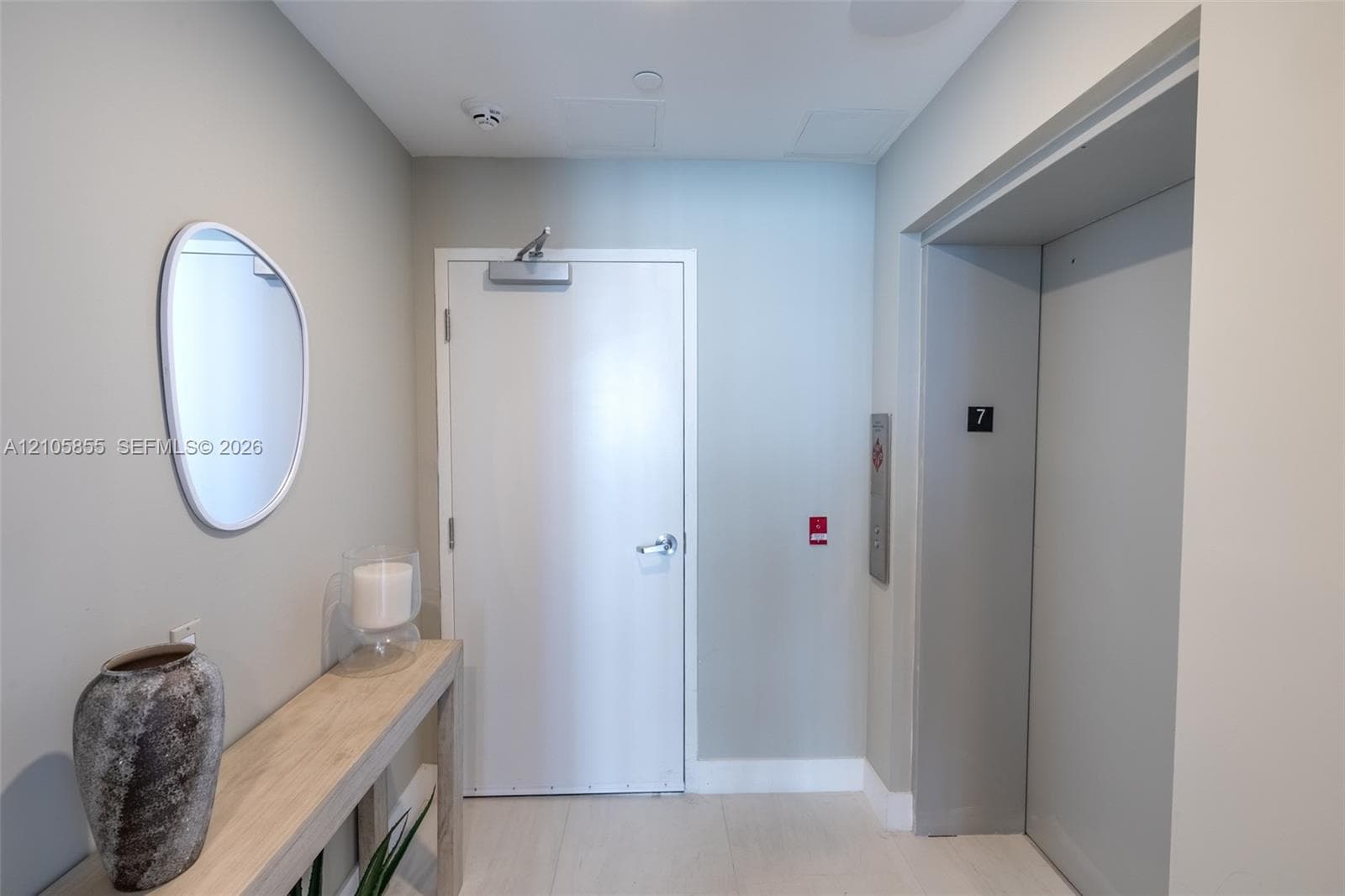 Entrance foyer featuring a solid-core entry door with hydraulic closer, private elevator access, and light-toned hard-surface flooring