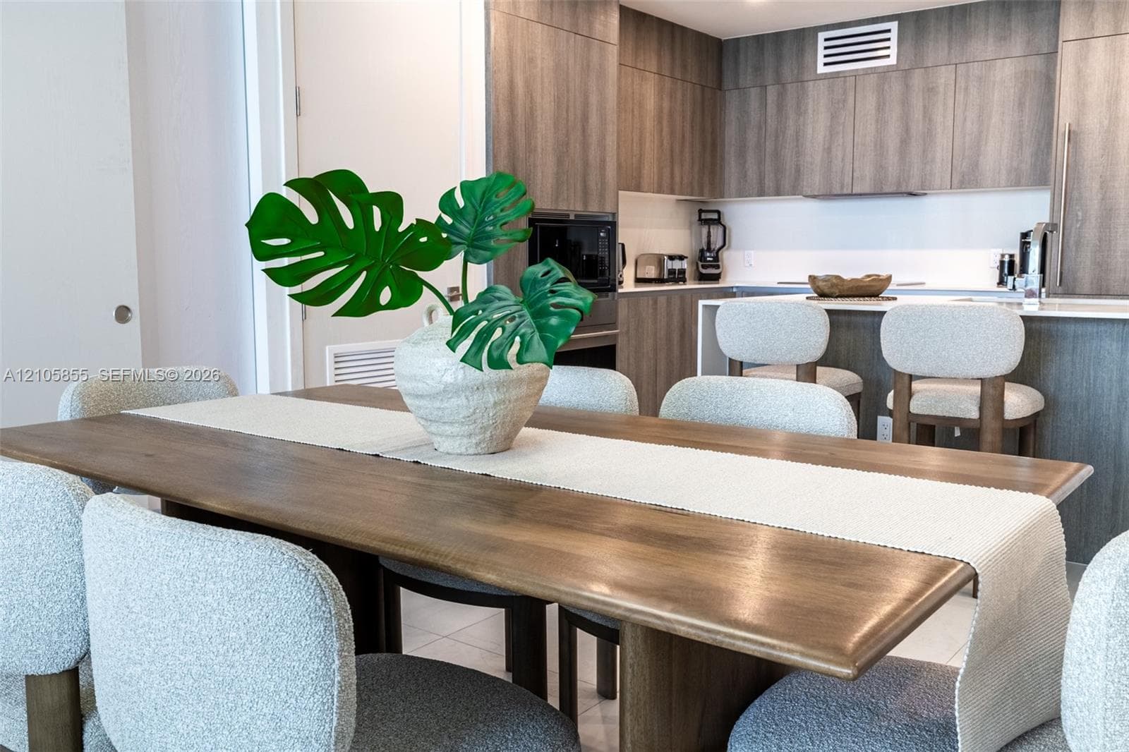 Kitchen featuring wood-finish cabinetry, stone countertops, and a breakfast bar