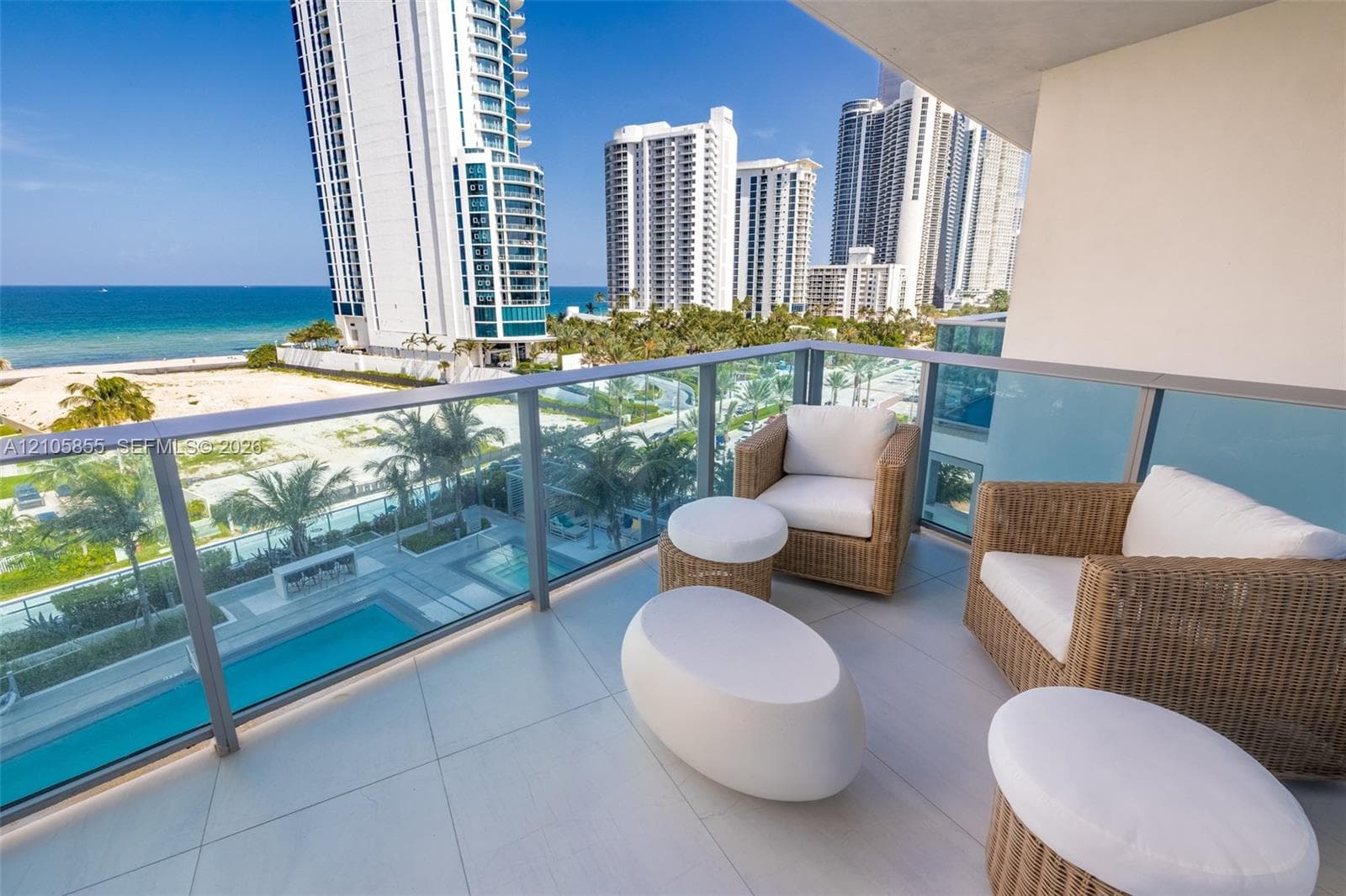 Private balcony featuring large-format tile flooring and a glass-paneled railing