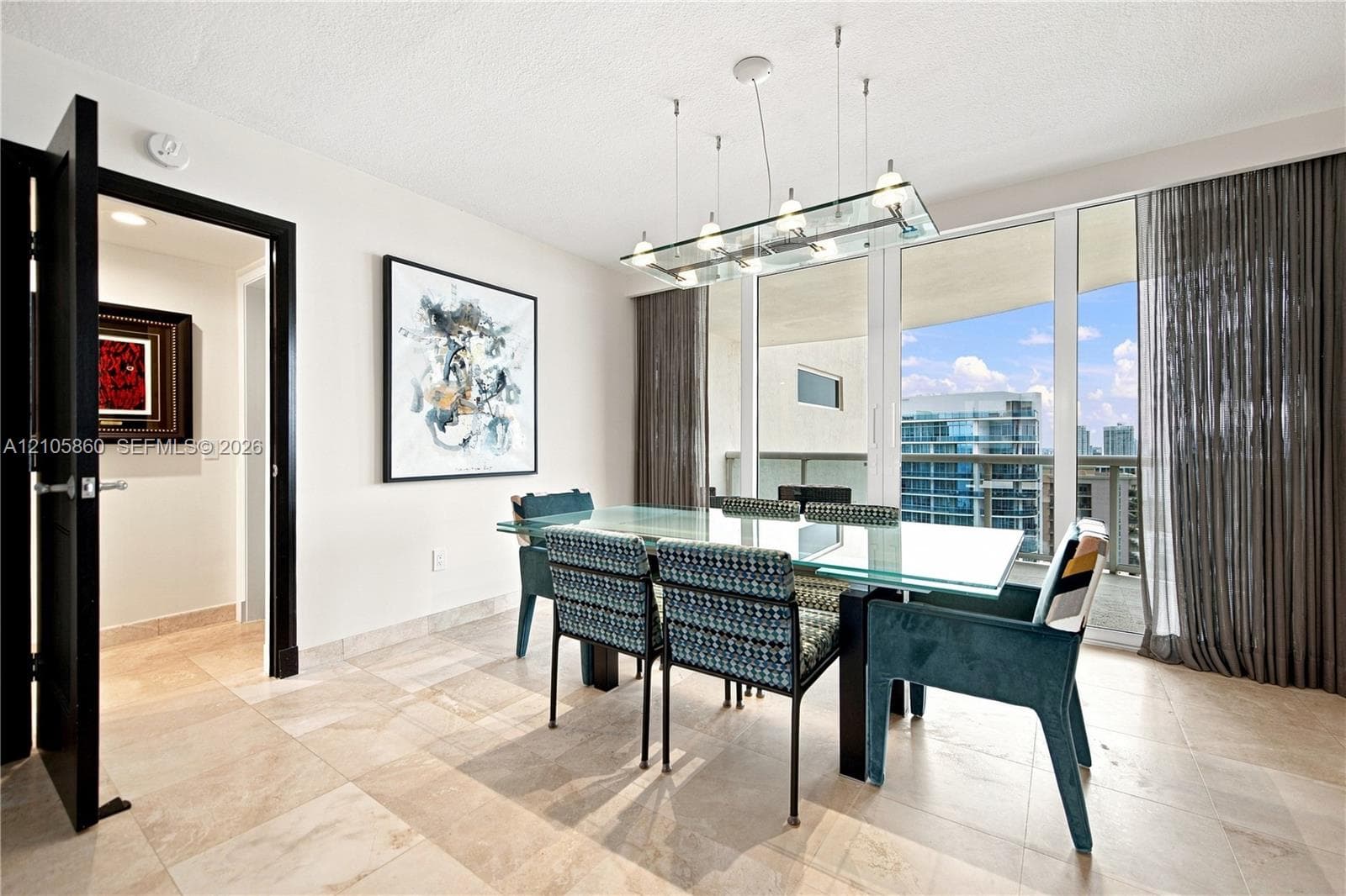 Floor-to-ceiling glass paneling, tile flooring, modern multi-light glass chandelier, and black-framed doorway