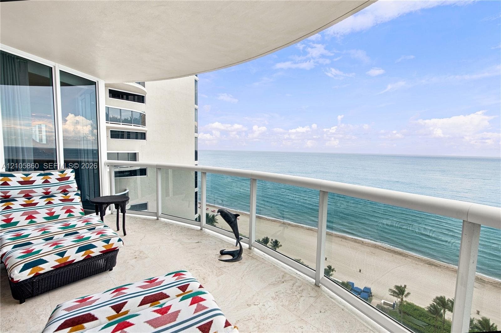 Covered balcony featuring stone flooring and a glass panel railing