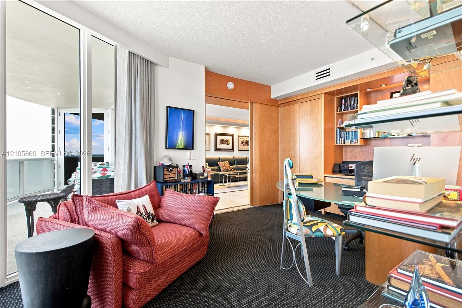 Floor-to-ceiling glass panel windows, built-in natural wood cabinetry, recessed lighting, and a sliding pocket door