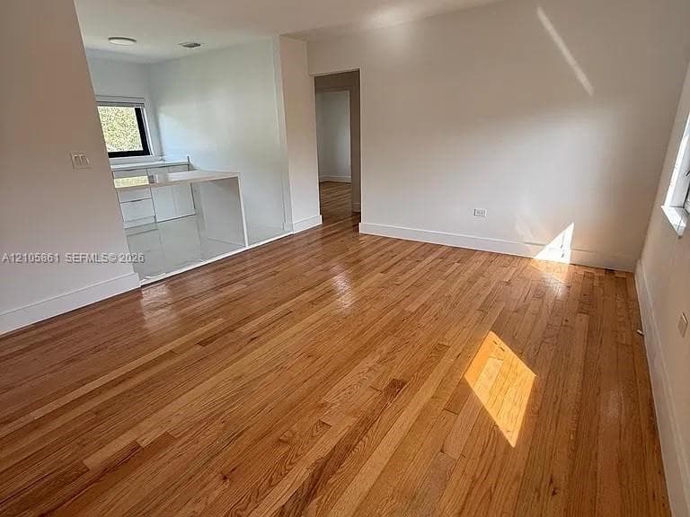 Interior space featuring wood-finish flooring, white cabinetry, solid-surface countertops, and recessed lighting