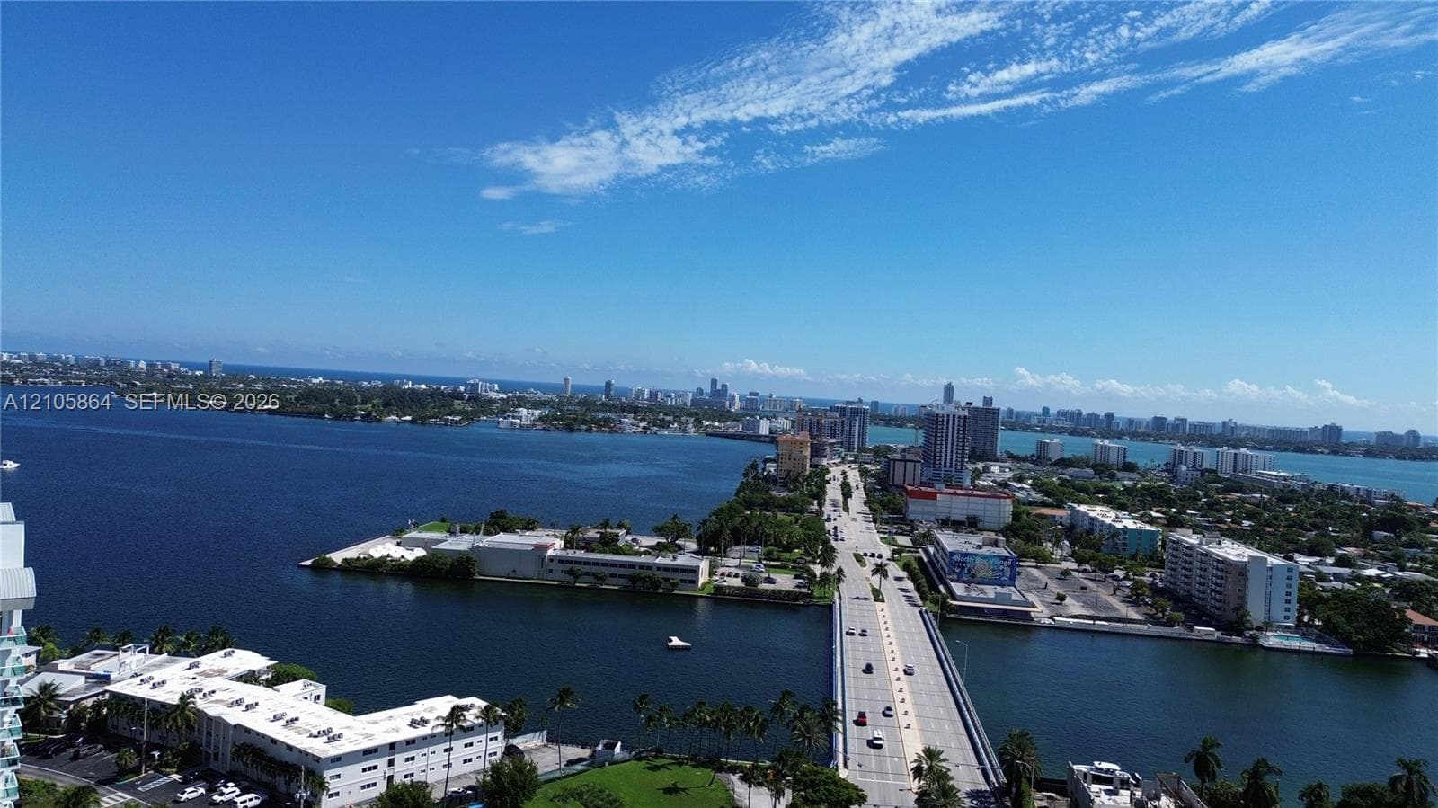 Aerial perspective featuring expansive waterway frontage, multi-level coastal development, bridge infrastructure, and maritime access points