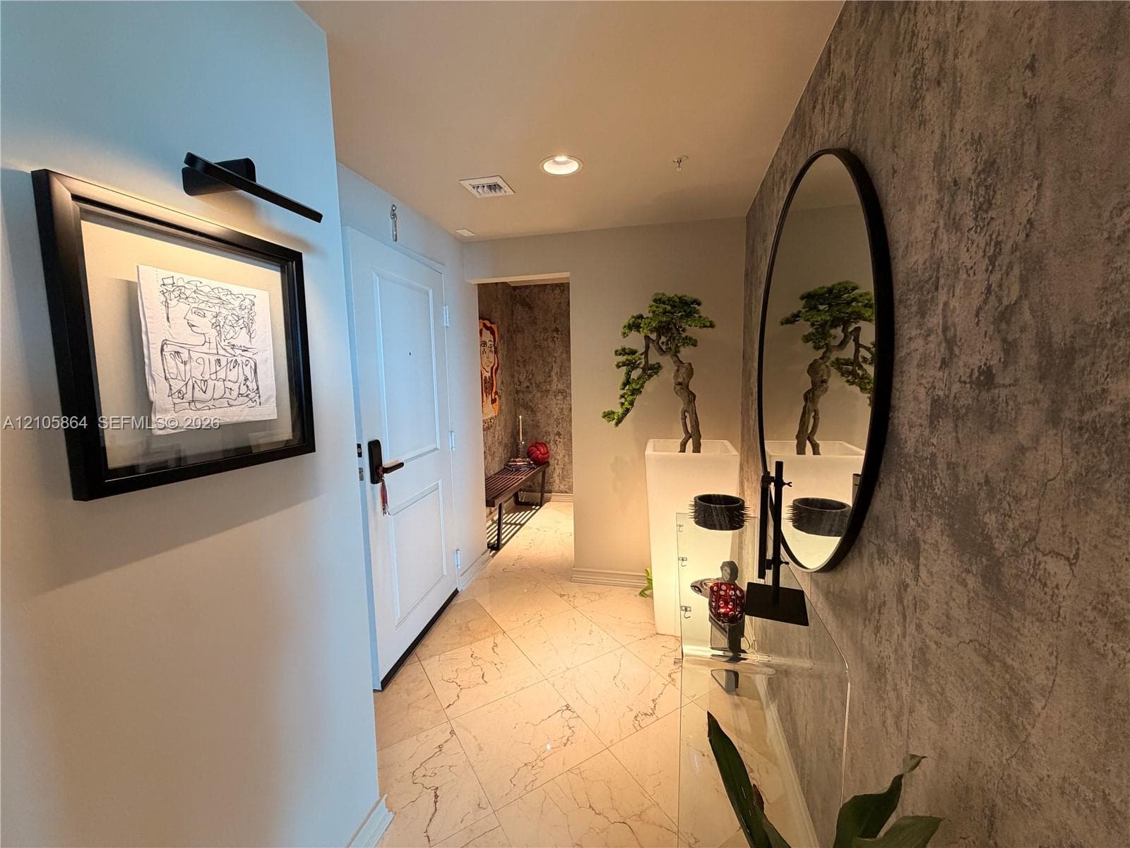 Foyer featuring large-format veined tile flooring, a textured stone-finish accent wall, and recessed lighting