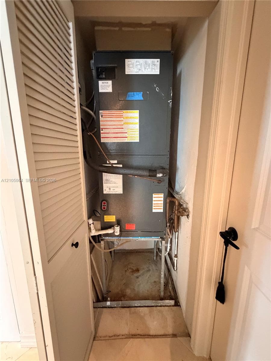 Dedicated utility closet containing an HVAC air handler unit, featuring louvered ventilation door access
