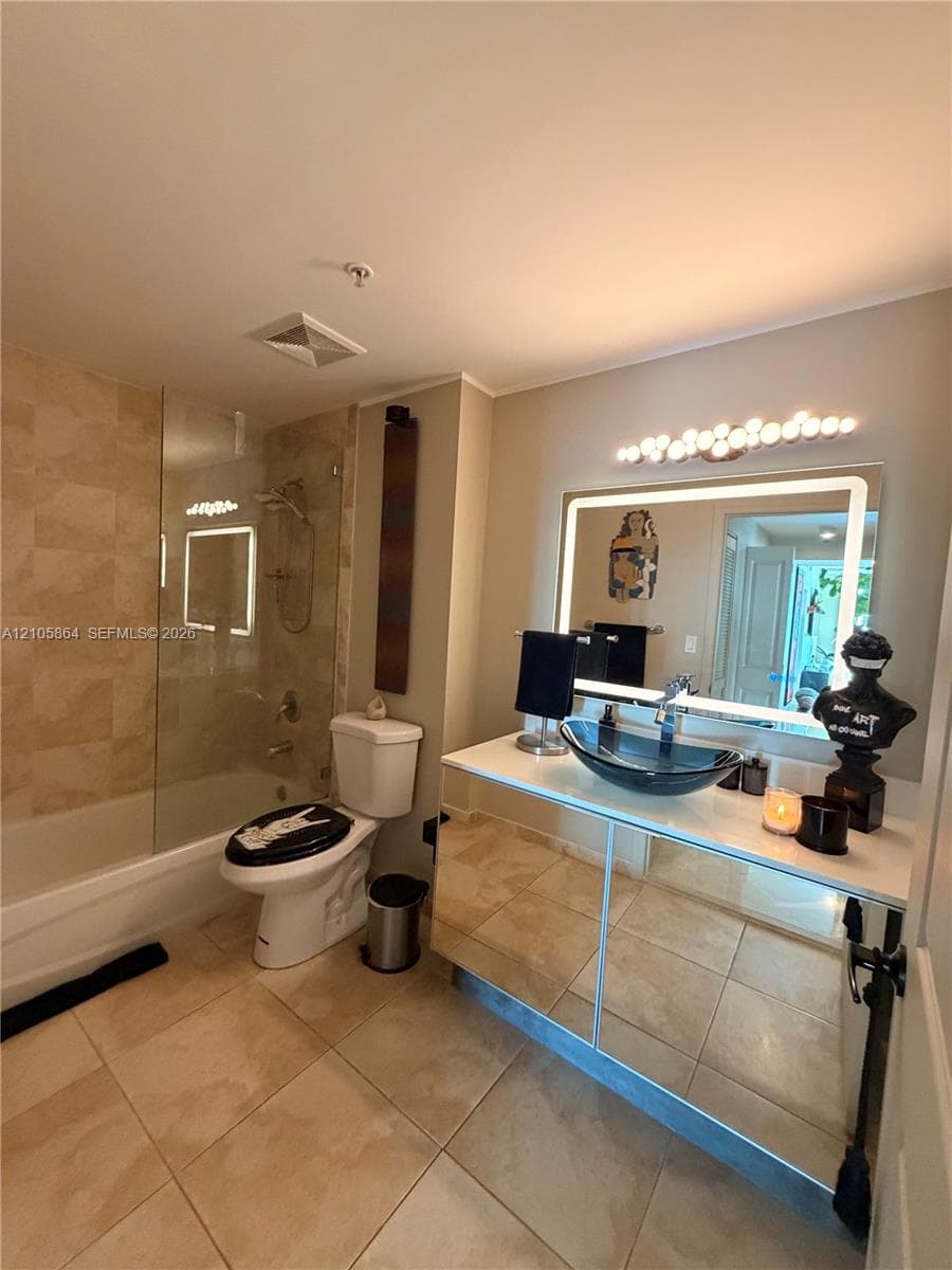 Bathroom featuring a floating vanity with a mirrored base, a rectangular vessel sink, and an integrated LED-lit vanity mirror