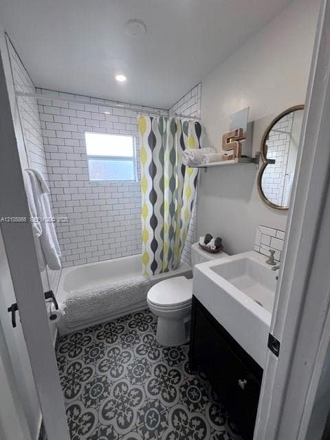 1/1 Bathroom featuring patterned floor tile, white subway tile shower surround, porcelain tub, and a vanity cabinet with a rectangular basin