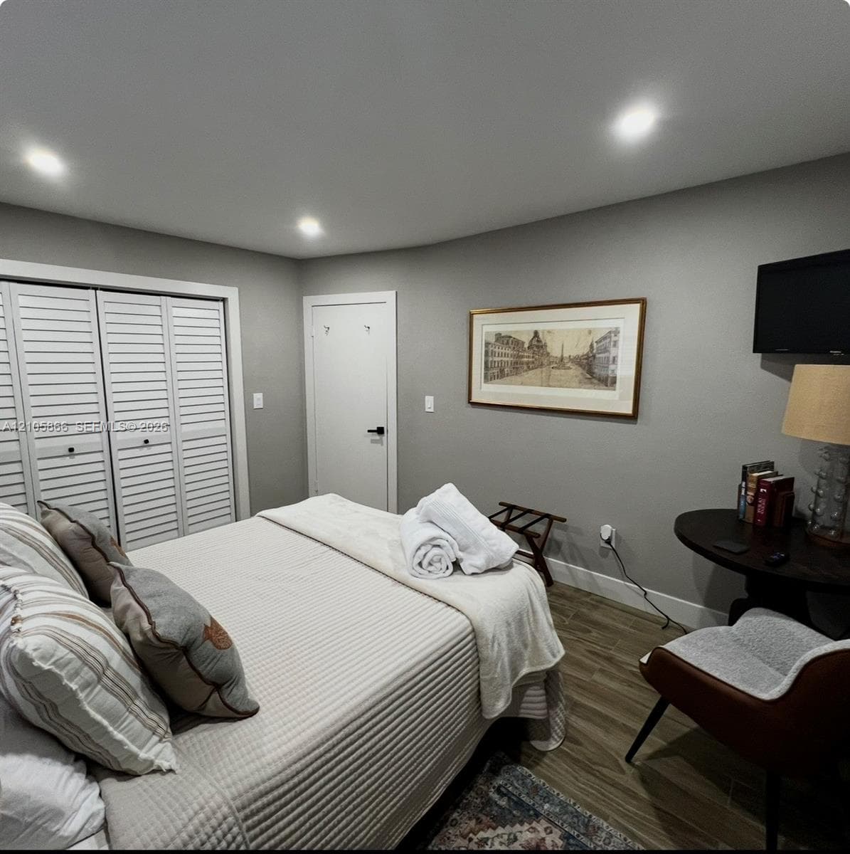 main house bedroom 2 Wood-finish flooring, recessed lighting, and white louvered closet doors
