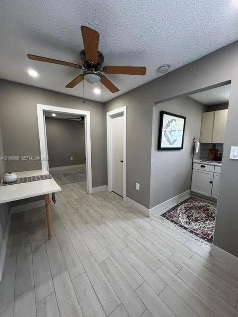 1/1 Interior space featuring neutral wall tones, wood-finish flooring, a ceiling fan with light fixture, and built-in cabinetry