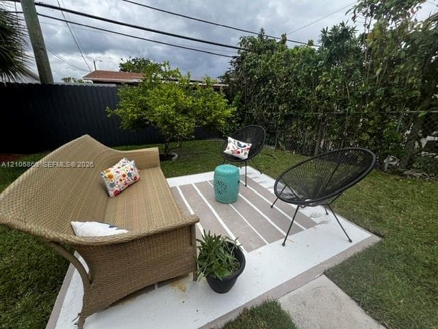 Painted concrete patio featuring a fenced rear yard with mature perimeter vegetation