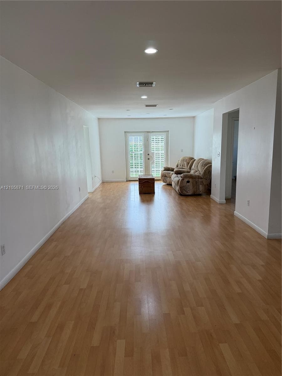 Wood-finish flooring, recessed lighting, and double glass-paned doors