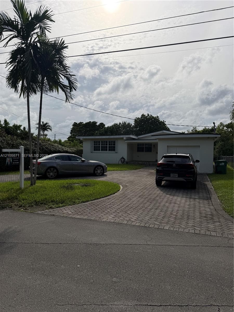 Single-story residence featuring a stucco exterior, an attached one-car garage, and a herringbone-patterned paved driveway