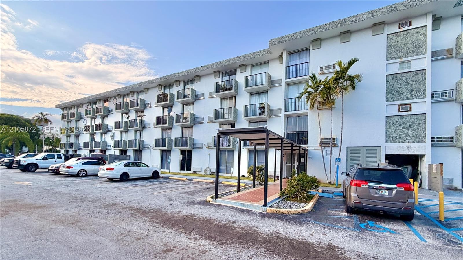 Multi-story exterior featuring individual balconies, a covered entryway, and stone-accented facade