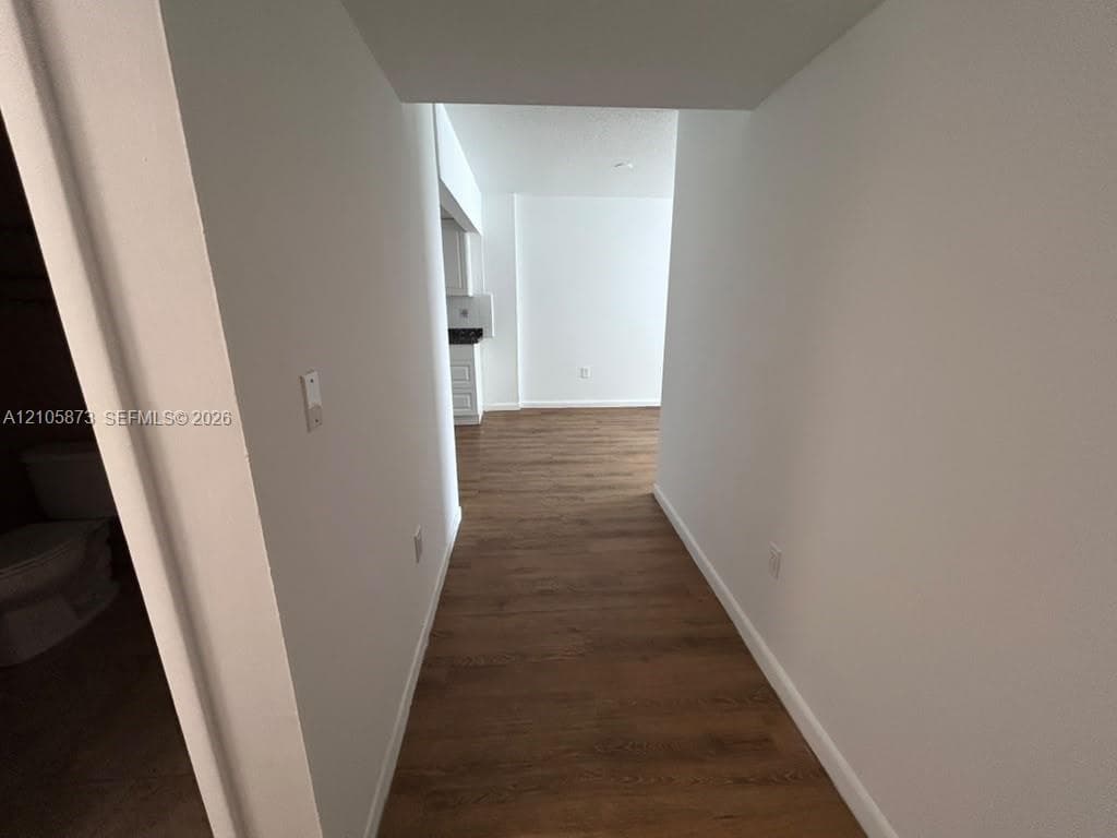 Interior hallway featuring wood-finish flooring and neutral wall paint