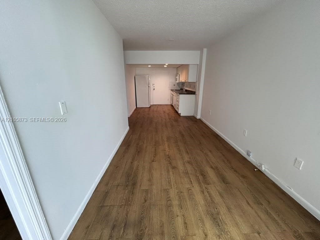 Open-concept interior space featuring uniform wood-finish flooring, neutral wall tones, and recessed ceiling lighting