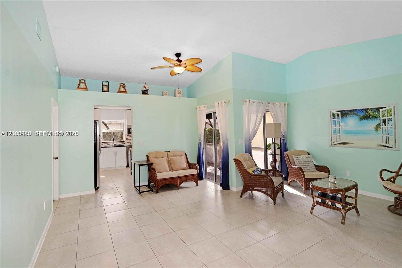 Vaulted ceilings, neutral tile flooring, recessed decorative wall ledge, and ceiling fan with integrated lighting