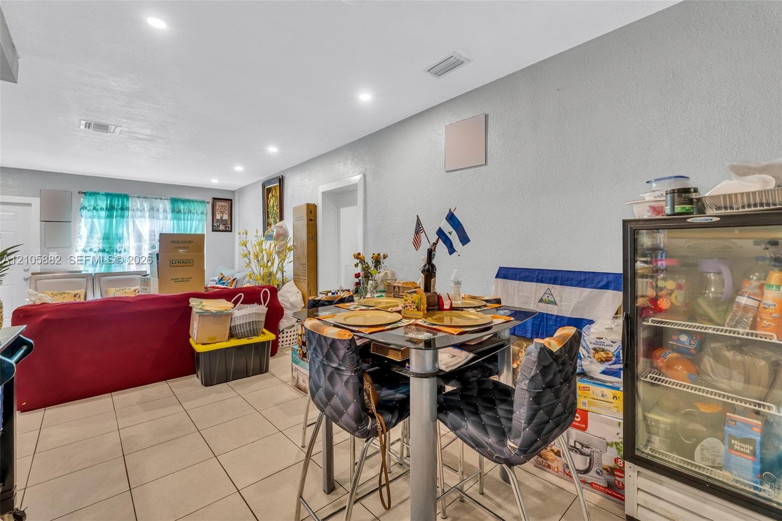 Open-concept interior featuring light-colored ceramic tile flooring, recessed lighting, and smooth-finish ceilings