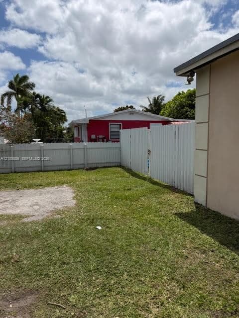 Outdoor area featuring a fenced perimeter and a lawn