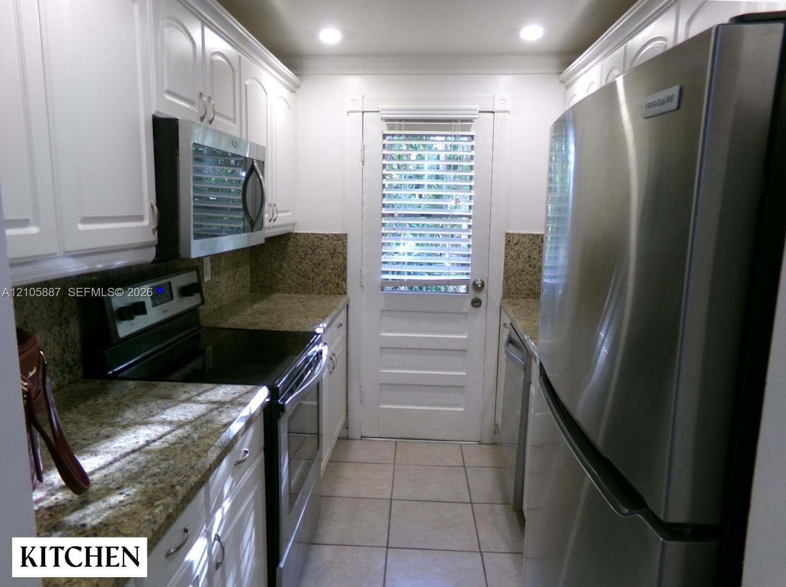 Kitchen featuring white cabinetry, stone-surface countertops, stainless steel appliances, recessed ceiling lighting, and tile flooring