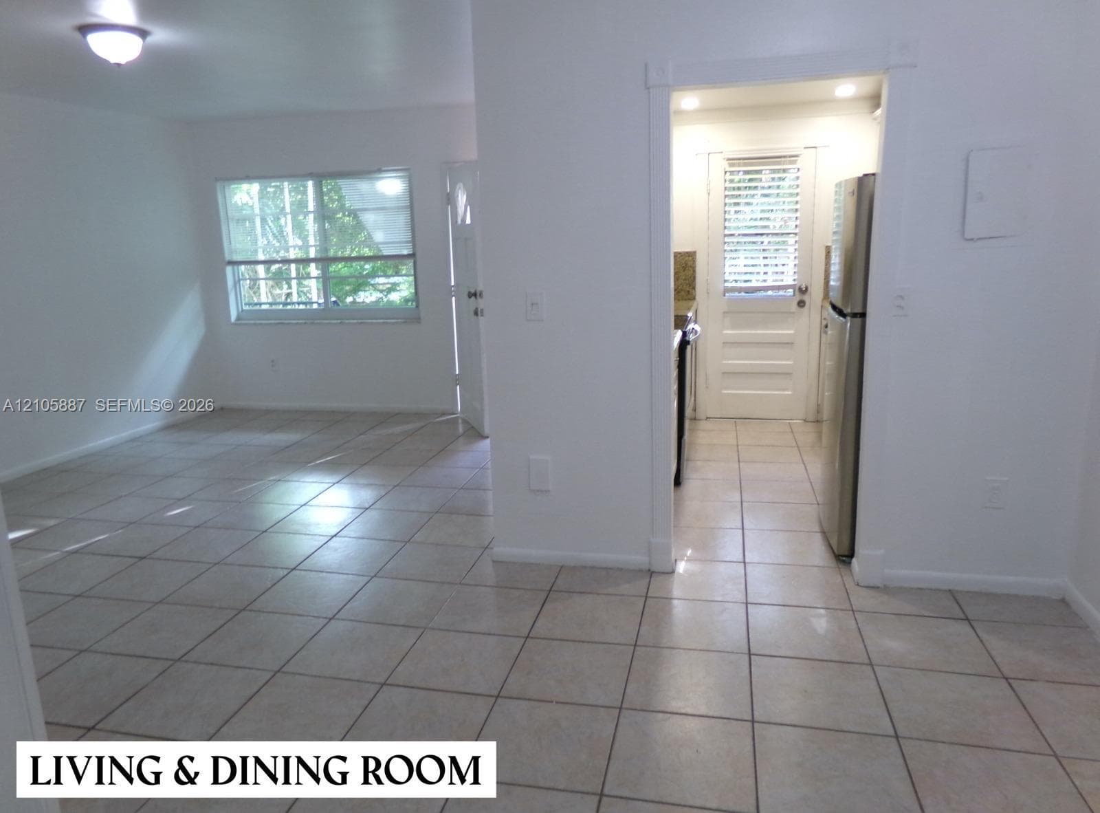 Ceramic tile flooring, neutral wall finishes, flush-mount lighting, and multi-panel exterior doors with inset glass