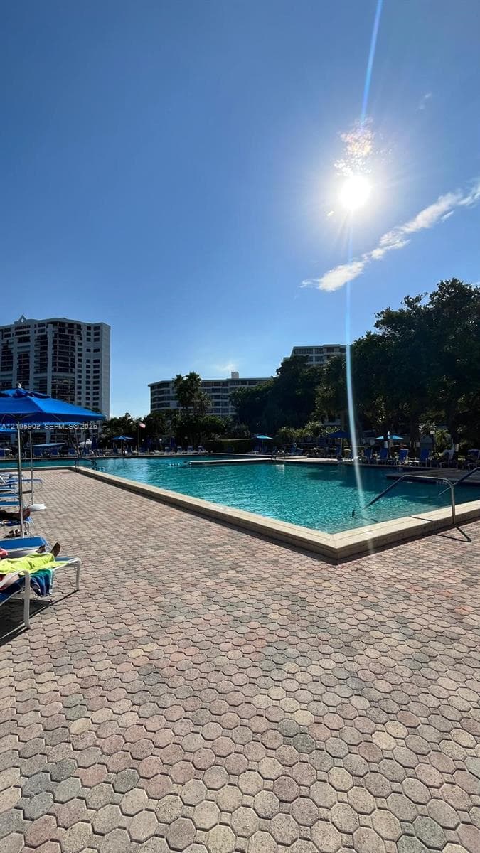 In-ground swimming pool with a concrete apron and paver-stone decking