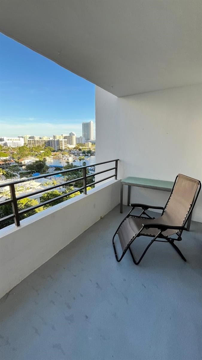 Covered balcony featuring a horizontal-rail metal railing and solid concrete flooring