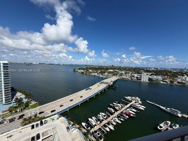 Elevated water scenery featuring a marina with docking slips, an expansive waterway, and bridge infrastructure