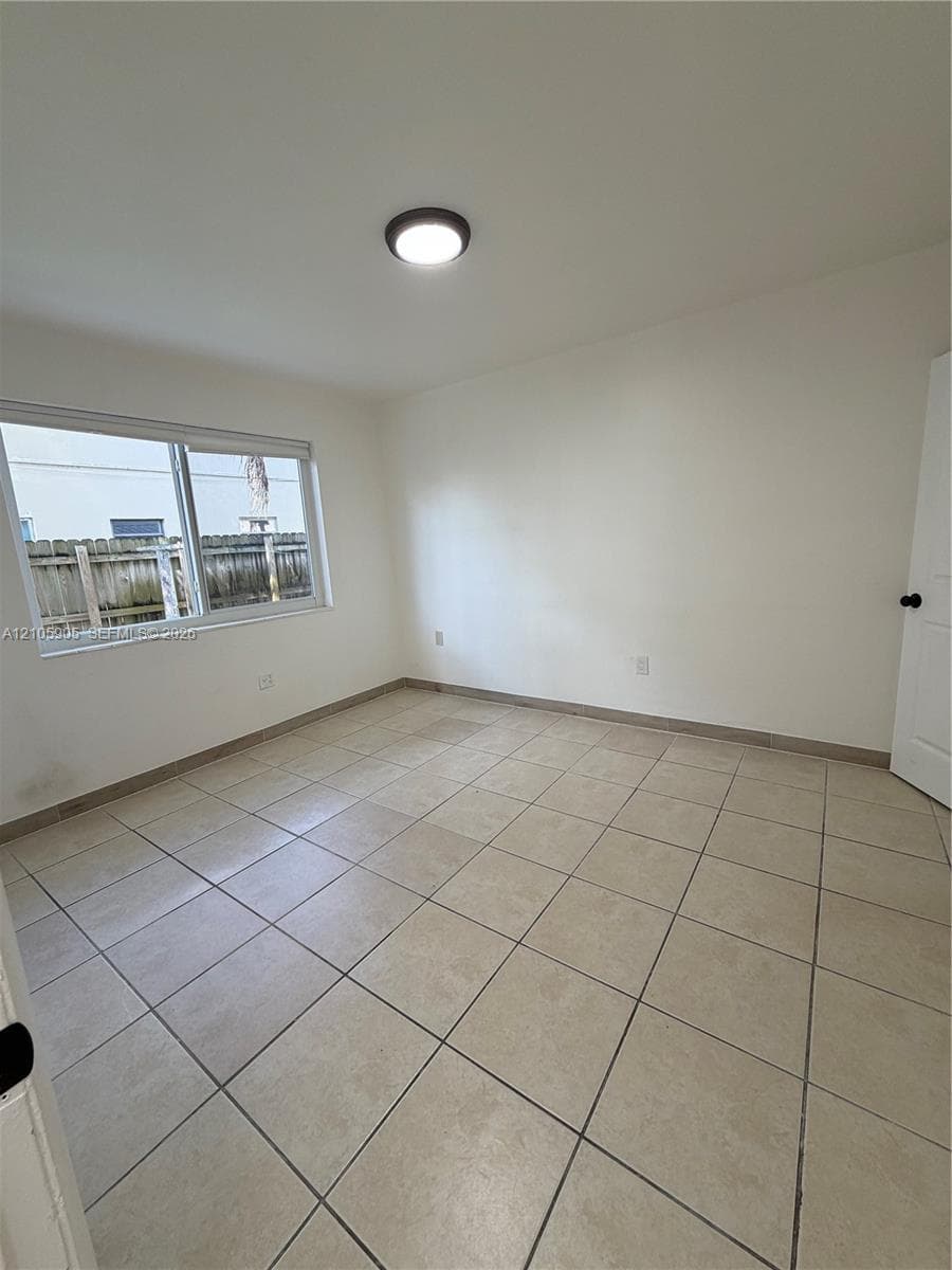 Neutral-toned tile flooring, recessed ceiling lighting, and a sliding glass window