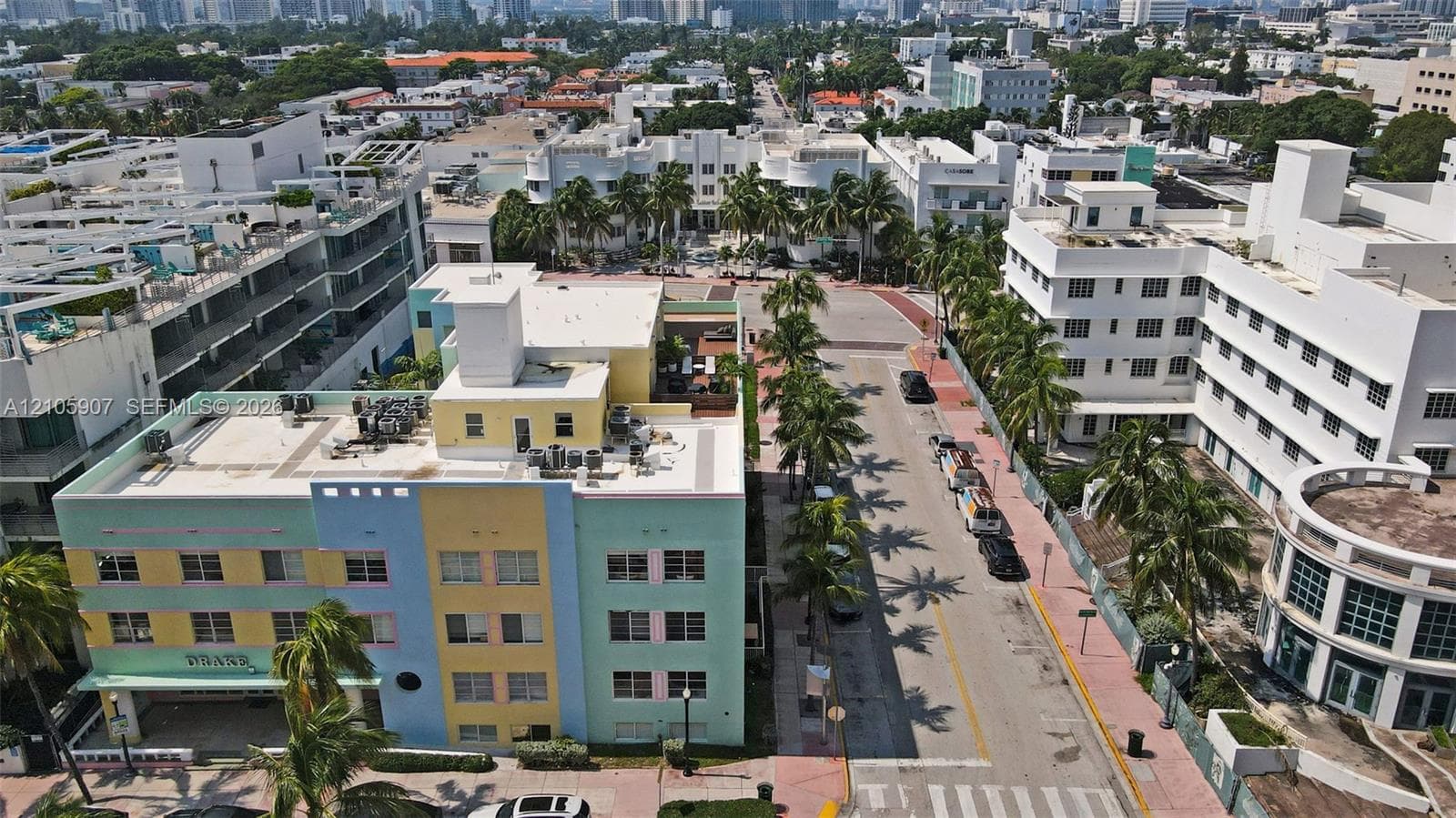 Aerial perspective of a multi-story, pastel-colored masonry building featuring a flat roof and ground-level storefront