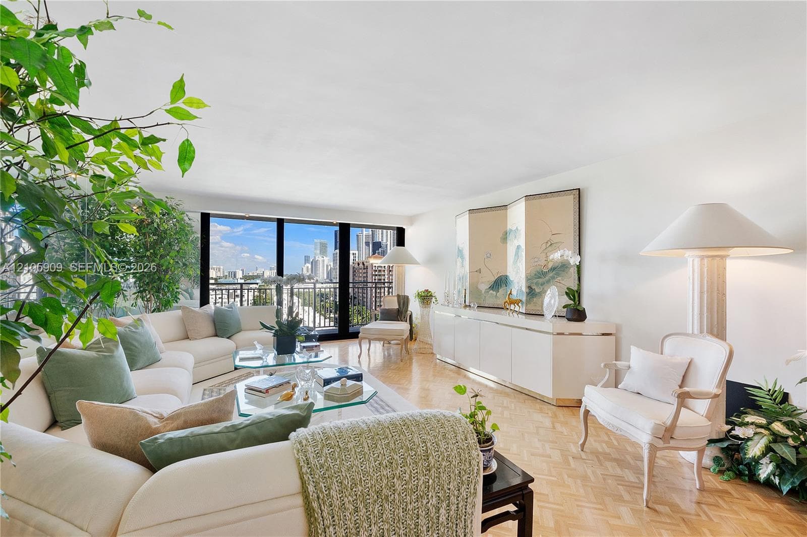 Living area featuring floor-to-ceiling windows, black metal balcony railing, and parquet wood flooring