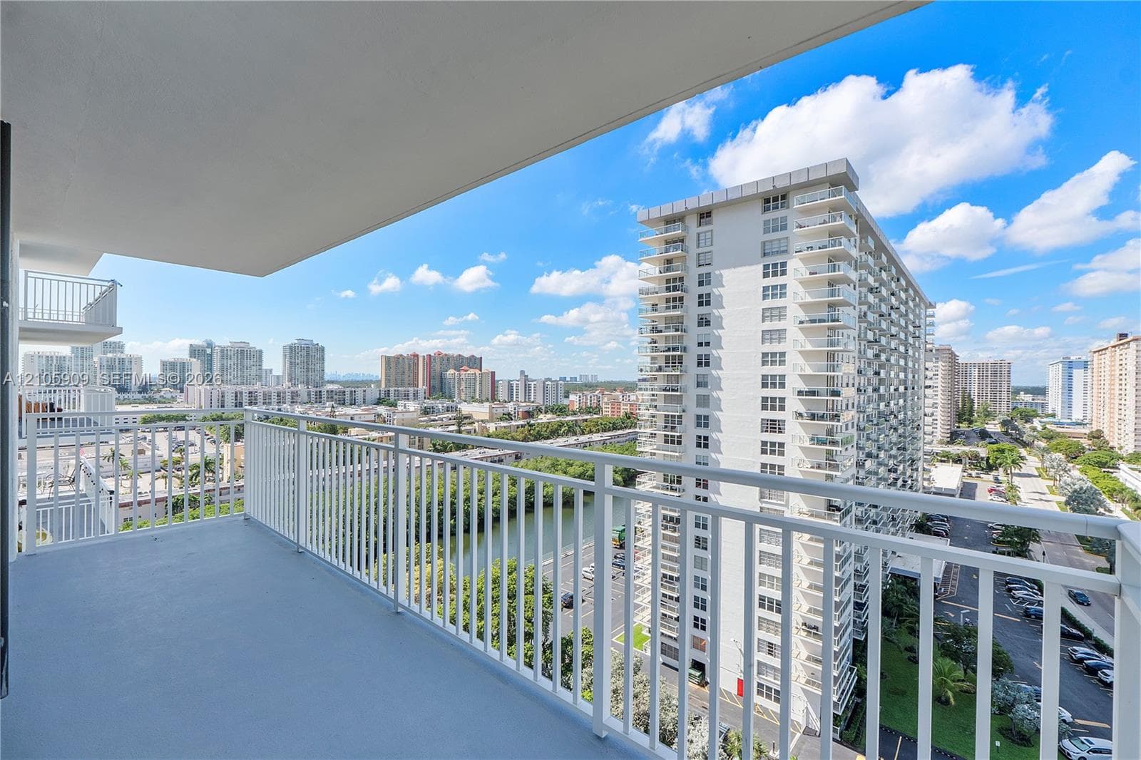 Private balcony with white metal railings and concrete flooring